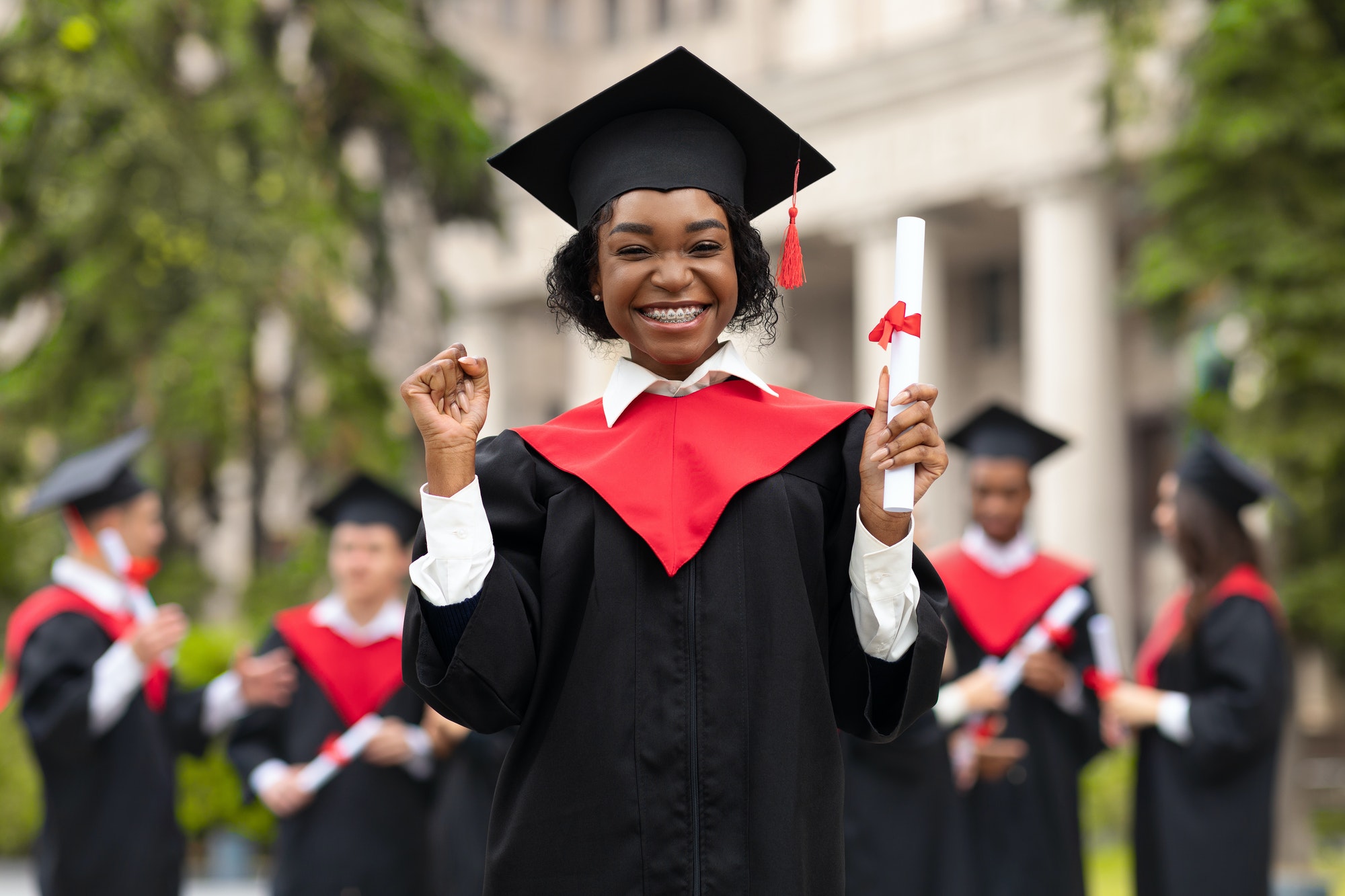 Cheerful african american young lady in graduation costume
